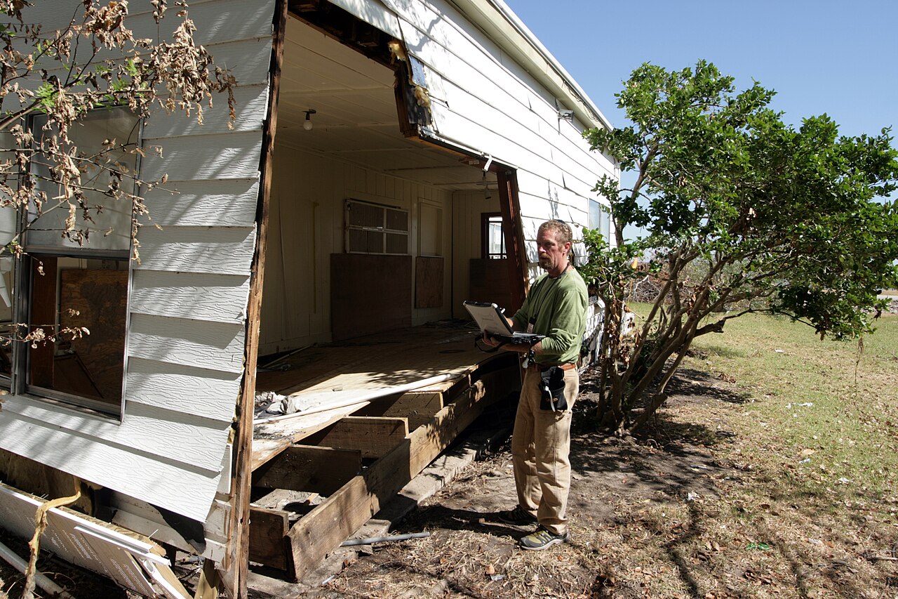 Home inspector reviewing exterior storm damage